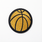 Basketball patch with gold ball and black outline on a white background