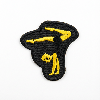 Embroidered patch with a yellow silhouette of a person on a balance beam on a black background